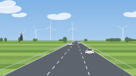 Fast leere dreispurige Autobahn durch flaches grünes Land mit Windmühle und Windrädern