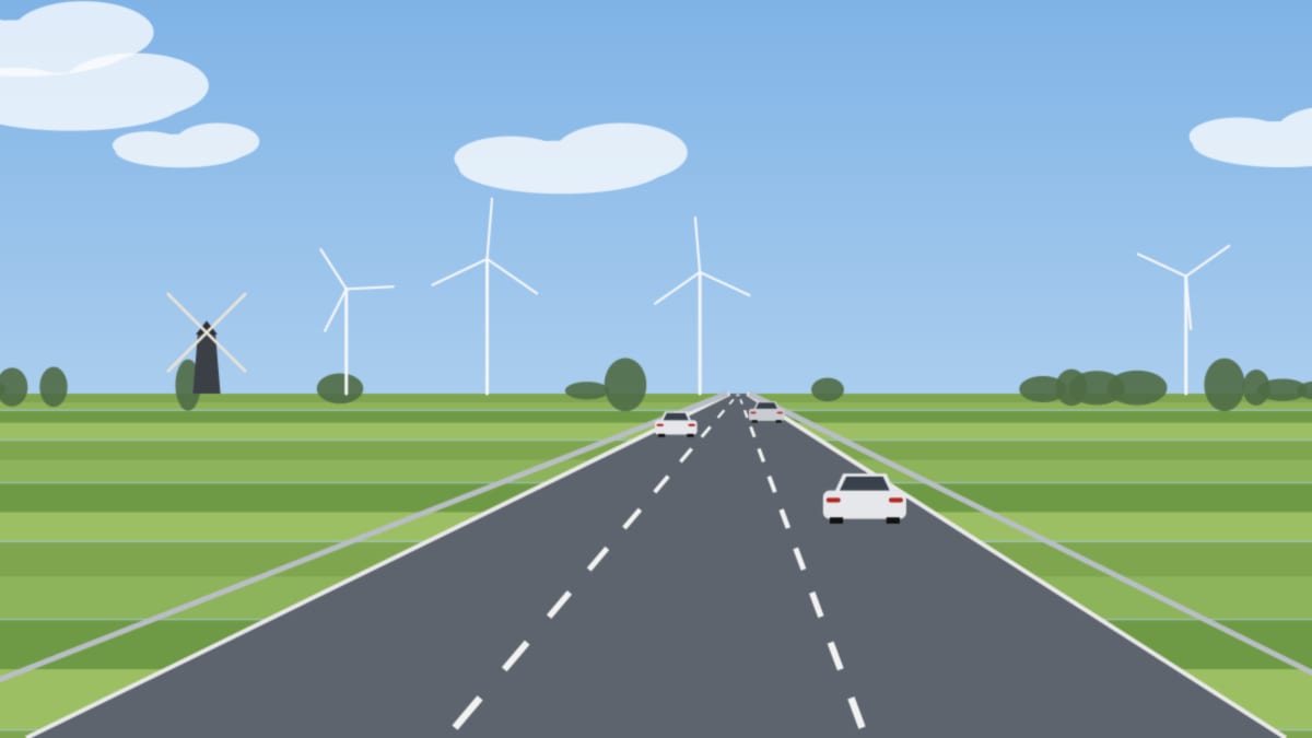 Fast leere dreispurige Autobahn durch flaches grünes Land mit Windmühle und Windrädern