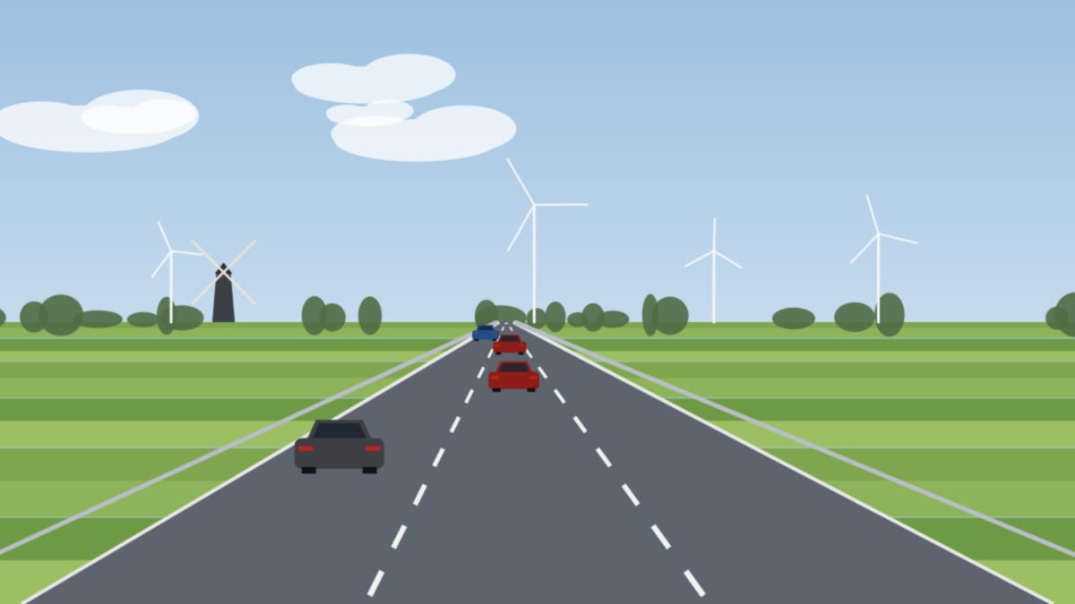 Dreispurige Autobahn durch grüne Felder mit Windrädern und einer alten Windmühle