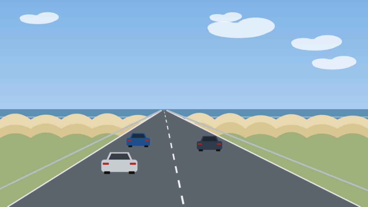 Straße hinter den Dünen am Meer mit wenigen Autos unter blauem Himmel