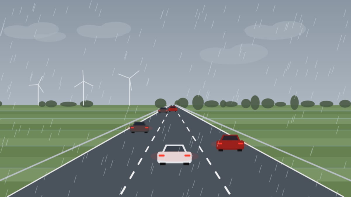 Nasse Autobahn bei Regen, Autos mit Licht, graue Wolken und Windräder über flachem Land