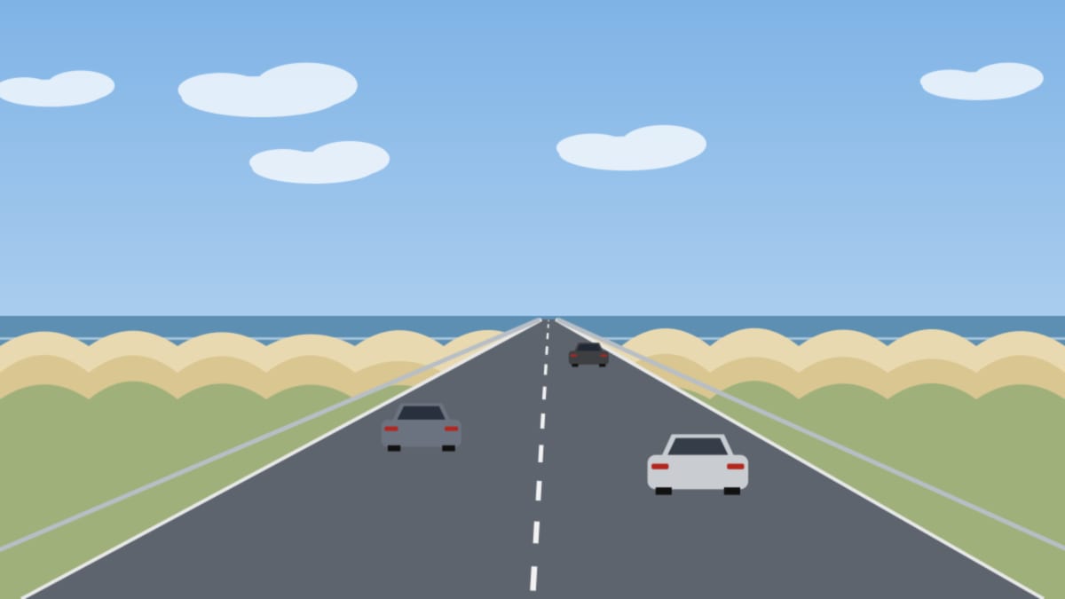 Straße hinter den Dünen am Meer, wenige Autos unter blauem Sommerhimmel